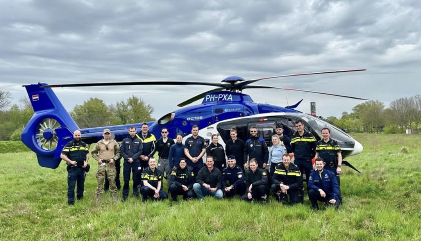 Participantes de un evento On Patrol junto a un helicóptero de la policía neerlandesa